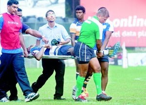 Even the match referee Dilroy Fernando and a St. Peter’s player had to lend their helping hands to take out an injured St. Joseph’s player out of ground at Longdon Place last week. 		 - Pic Courtesy of Dhammika Heenpella