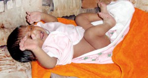 Nobody’s baby: At the police station oblivious to all that has happened. Pix by Suranga Rajanayake