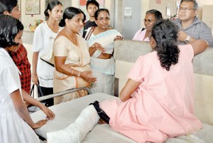 Museum director Dr. Saroja Wettasinghe speaks to one of the teachers who sustained injuries. Pix by Indika Handuwala  and Susantha Liyanawatte