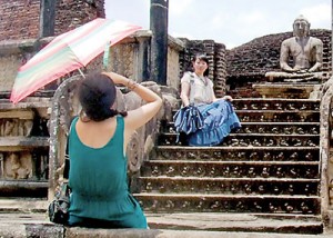 A young tourist girl poses in front of an ancient monument