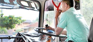 Distracted: This bus driver seems to be concentrating on everything but his driving a weighty problem on his mind, a phone in his hand