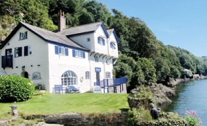 The house she loved (top) and (right) Daphne du Maurier rowing across Fowey estuary to “Ferryside’