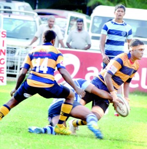 A Royal player tries to offload as he is being brought down by a Wesley defender. - Pic Ranjith Perera