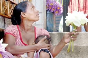 “Come, buy my flowers”:  Shiromi has no option but to be back at the Kalutara temple premises (below) tomorrow.  Pix by Ratnasiri Premala