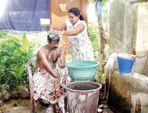 Priyani attends to her husband’s daily needs. Pix by Athula Bandara