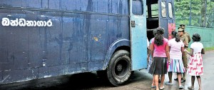 All aboard: Under-aged girls (above) and adult offenders (below) all transported in one bus to courts. Pix by Amila Gamage