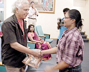 The author presents a book to Dr. Wickramabahu Karunarathne