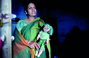 Sarita Gupta, 51, a yoga teacher, holds a doll belonging to her missing fifteen-year-old daughter Ambika inside her house in New Delhi (REUTERS)