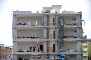 People stand in a damaged building on May 14, 2013 at Reyhanli in Hatay, just a few kilometres from the main border crossing into Syria. The death toll in twin car bombings in a Turkish town near the Syrian border has increased to 50 after another body was recovered and a victim died in hospital, the health minister was quoted as saying on May 14 (AFP)