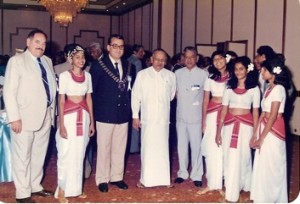 Picture taken at the 15th SKÅL Asian Congress held in Colombo in 1986 at the Colombo Hilton. From left - Jim Power, (Secretary General SKÅL International), Antonio Garcia del Valle (President SKÅL International), Minister of State Anandatissa De Alwis and  Sojii Roberts, (President SKÅL Bangkok) among a troupe of  singers.