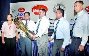 CBL Group Director Nandana Wickramage (2nd Left) hands over the OWSC Munchee 6s Trophy to OWSC President S. Renganathan (centre). - Pic by R. Perera
