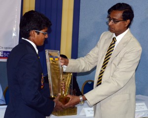 Royal College hockey captain Shahid Hussain officially hands over the Blue and Gold Trophy to his principal Upali Gunasekara. - Pic by Hasitha Kulasekara