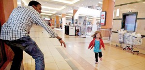 Their story: Portia Walton runs for the safety of Kenya mall hero Abdul Haji. The Waltons have now shared their harrowing tale, giving backstory to this now-iconic photo (Reuters)
