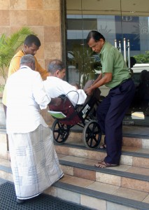 An elderly shareholder being given a helping hand to attend the AGM. Pic by Nilan Maligaspe.