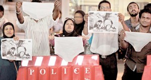 Male, MALDIVES: Maldivian activists wave underwear and cartoons as they stage a protest in Male on September 26. AFP PHOTO