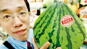 A man holds a pyramid-shaped watermelon in Tokyo. With melons that sell for the price of a new car and grapes that go for more than 100 USD a pop, Japan is a country where perfectly-formed fruit can fetch a fortune (AFP)