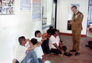 A police officer questioning the would-be boat people Pic by Sarath Siriwardena