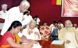 Ananthi Shashitharan who came second on the preference vote count signing her letter of appointment as councilor after she took oaths before Chief Minister C.V.Wigneswaran. The Consul-General of India in Jaffna looks on. Pic by Priyantha Hewage