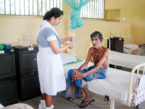 At the hospice in Kurundankulama, Anuradhapura: A nurse tends a cancer patient
