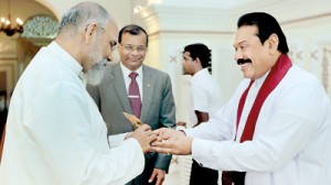 President Mahinda Rajapaksa gifts the statue of Hindu god Sri Vinayagar to Northern Province Chief Minister C.V. Wigneswaran after he was sworn in. Looking on is Northern Province Governor retired Major General G.A. Chandrasiri.  Pic courtesy Presidential Secretariat