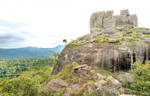 At the top. The unusual formation on the top of the rock is the ‘peak’ of Utuwankande