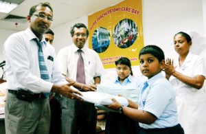 A Belvoir student hands over the donations to LRH Director Dr. Rantnasiri Hewage
