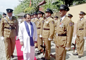 Governor Tikiri Kobbekaduwa inspects the guard of honour with the Officer-in-Charge of the Balagolla police