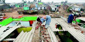 Women repair the roof of their houses at the cyclone-hit Nalianuagaon village in Ganjam district in Odisha (REUTERS)