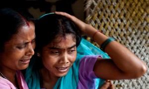 An alleged Indian human-trafficking victim (R) is hugged by her sister after being rescued  (AFP)