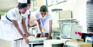 The staff meticulously locating and collecting electronic waste (e-waste). Pix by Indika Handuwala