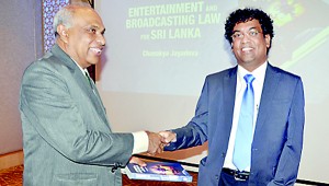 The author presenting a copy of book to the Attorney General Palitha Fernando.  Pic by Ranjith Perera