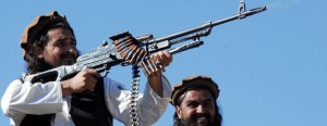 This AFP file picture taken on November 26, 2008, shows  Hakimullah Mehsud (L) firing from a rifle as he poses for journalists in the Mamouzai area of Orakzai Agency.