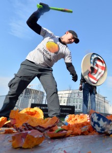 A Ukrainian activist wearing a T-shirt reading "I hear everything !" breaks Halloween pumpkins painted with the colours of the American flag and mounted with headphones, as another activist holds a sign made from a satellite dish with an ear painted in the colours of the American flag, as they protest  on Friday in Kiev over US surveillance of European citizens. AFP