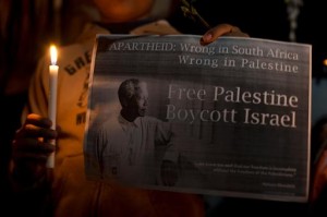 A Palestinian youth holds a portait of Nelson Mandela, during a candle vigil in Gaza City on December 8 (AFP)