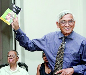 Publisher Vijitha Yapa holds the book triumphantly as the author’s father Sam Wijesinha looks on. Pix by Indika Handuwala