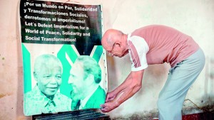 A Cuban hangs a poster of Cuban former president Fidel Castro and South African president Nelson Mandela at his home in Havana, on December 6, 2013. The Council of State of Cuba decreed official mourning on Friday and Saturday at the death "of close friend" Nelson Mandela and will become national mourning on Sunday, with the suspension of festive activities AFP