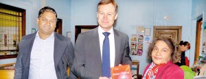 Rupa Monerawela, presenting a copy of her historical novel ‘The Bridge of Perfect Wisdom’ to Matthew Offered, MP for Hendon, recently while her son looks on