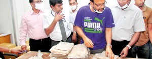 Custom officials inspect the packets of heroin found in the cans of grease (above) that arrived in a consignment from Pakistan