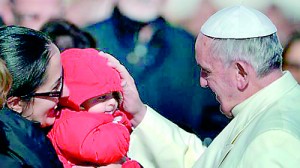 Pope Francis blesses a baby during his general audience in St Peter's Square  (AFP)