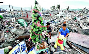 A typhoon Haiyan survivor decorates a Christmas tree amid the rubble of destroyed houses in the City of Tacloban in central Philippines (Reuters)