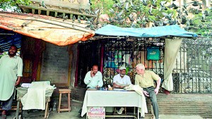 Indian letter writers wait for customers at their roadside stalls located opposite the General Post Office in Mumbai (AFP)