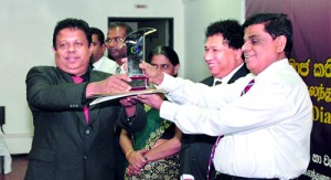 Sunil Rajapaksha Manager HR & Productivity Improvement of H J S Condiments Limited  receives the Silver award from Mahinda Madihewa Secretary to the  Ministry.