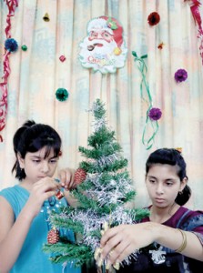 Christmas away from home:  Kashmala and Rashami  decorate a small tree.        Pix by M.A. Pushpa Kumara