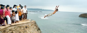 Suspended in mid-air: Watched by an anxious crowd, a cliff-jumper makes the leap . Pix by M.A. Pushpa Kumara