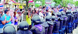 Thai anti-government protesters rally next to riot policemen (AFP)