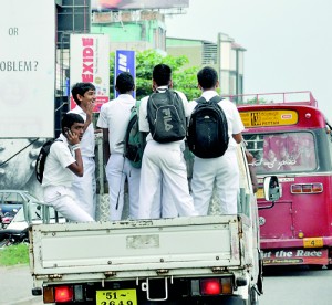 A packed bus in front of them, this batch of students have chosen an innovative if dangerous mode of transport to get to their destination