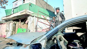 Afghan special forces soldiers stand guard next to the damaged entrance of a restaurant that was attacked in Kabul (AFP)