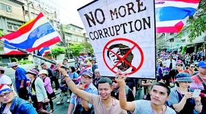 Thai anti-government protesters hold protest placard as they parade during a rally in Bangkok on January 18 (AFP)