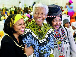 Former South African President Nelson Mandela celebrates his 86th birthday with his wife Graca Machel, left, and ex -wife Winnie Madikizela Mandela, right, in his rural home town of Qunu in the Eastern Cape Province on 18 July 2004 (AFP)
