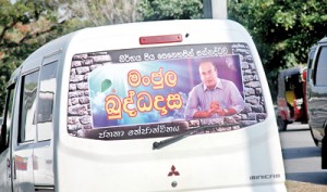 Election posters are seen to cover the rear windscreen of even private buses